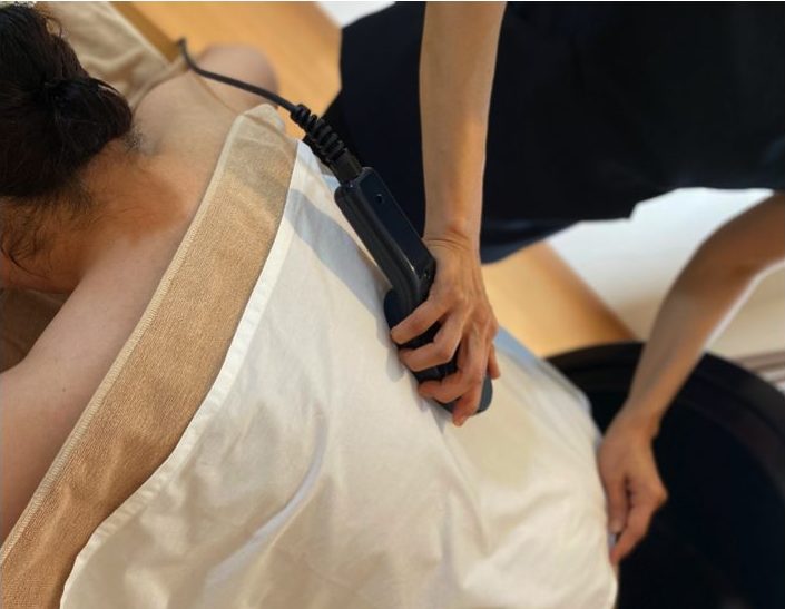 ミネラル温熱器を背中に当てている施術画像