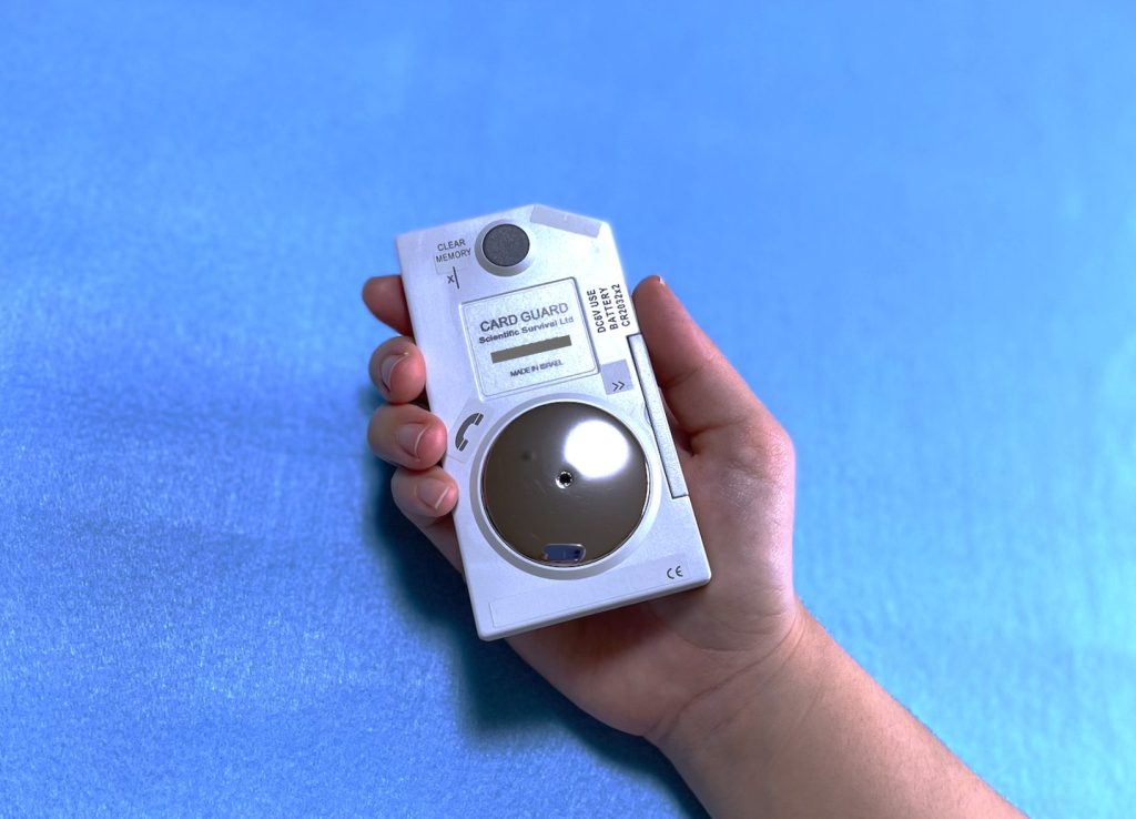 手で携帯型心電計を持つ画像