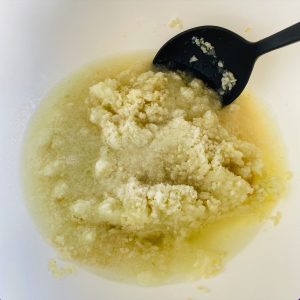 冷凍生麹、塩、玉ねぎ、水をボウルに入れ、ヘラで混ぜている様子