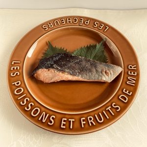 オーブントースターで焼かれた塩麹味の鮭の切り身１切が、大葉と一緒に皿に盛られた様子