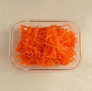 スライサーで細かく千切りされた人参が保存容器に入れられた様子